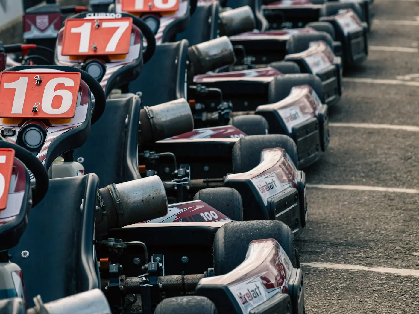A row of numbered racing karts lined up on a track
