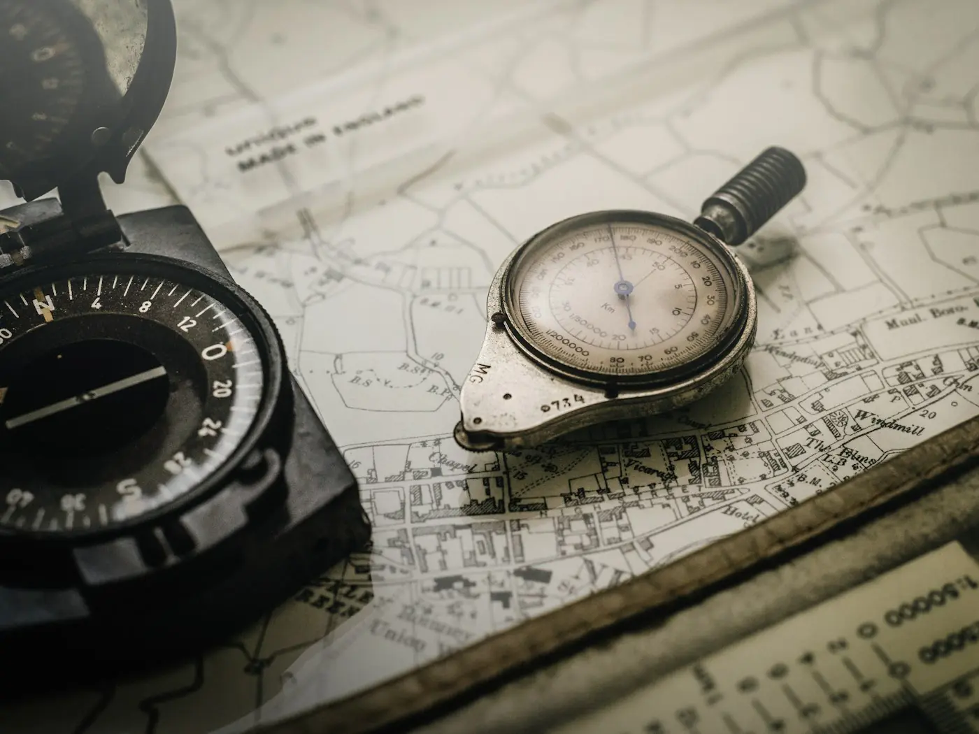 A compass, a stopwatch and a road map laid out on a table